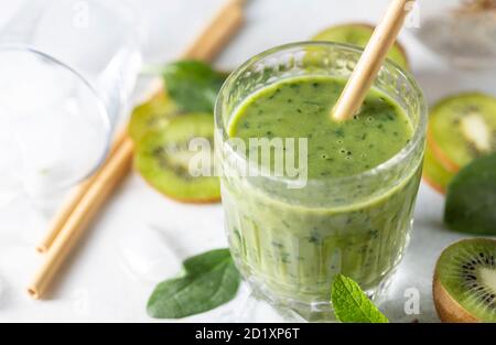Detox green smoothie - kiwi, spinach and matcha on a light grey slate, stone or concrete background. Stock Photo