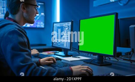 Smart Male IT Programer Working on Desktop Green Mock-up Screen Computer. Software Development Code Writing Website Design Database Architecture Stock Photo