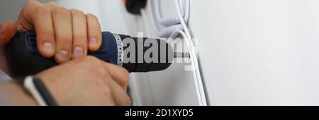 Man holds hammer drill in his hands and drills hole. Stock Photo