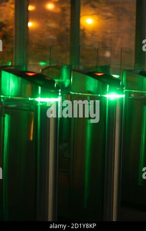 Night scene with two turnstiles with green led lighting without people vertical orientation Stock Photo