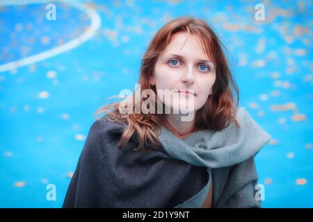Outdoor football game area on the street. A young woman stands on a hockey court. Autumn weather on the open sports field with blue coating. Stock Photo
