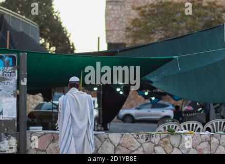 jerusalem, israel. 04-10-2020. A Jewish man wrapped in a tallit prays outside the synagogue on Sukkot, due to emergency regulations to prevent corona Stock Photo