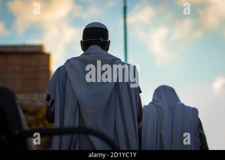 jerusalem, israel. 04-10-2020. A Jewish man wrapped in a tallit prays outside the synagogue on Sukkot, due to emergency regulations to prevent corona Stock Photo