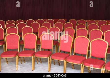 Red colored chairs with gold colored metallic frame arranged in circular shape for wedding reception Stock Photo