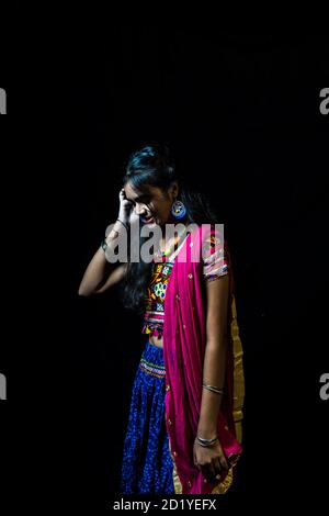 indian girl in traditional chaniya choli for navratri with a fashionable hairstyle poses in studio on black background navratri is an indian festival