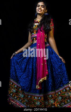 Indian girl in traditional chaniya choli for navratri with a fashionable  hairstyle poses in studio on black background. Navratri is an Indian  Festival Stock Photo - Alamy