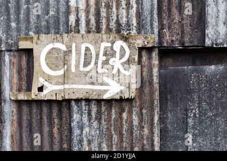 Old painted cider sign on the outside of a tin shed Stock Photo