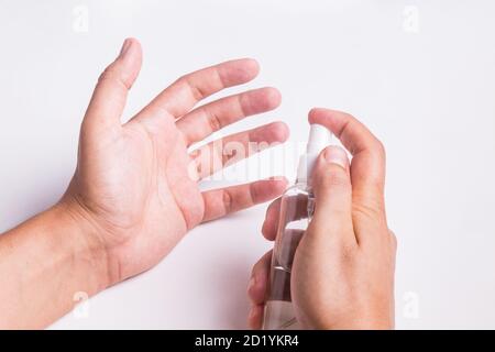 Hand holding plastic spray bottle of antiseptic - Closeup cleaning her hands with sanitizer solution Stock Photo