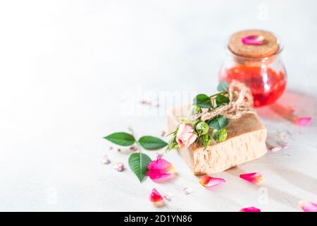 Organic handmade soap, pink rose bud on a white concrete background. Natural and non-waste cosmetic ingredients. Healthy lifestyle concept. Stock Photo