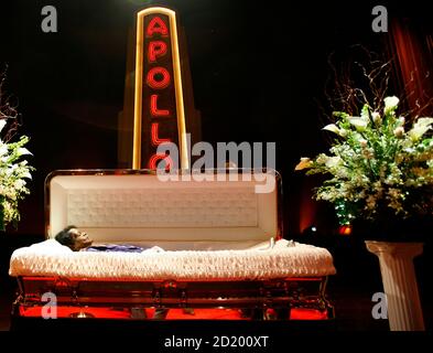 The body of James Brown lies in an open casket as viewers walk by ...