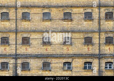 Old abandoned jail brick wall and cell windows with metal bars Stock Photo