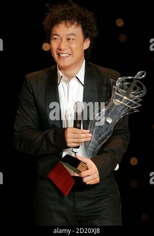 Hong Kong singer Eason Chan Yik-shun poses with his trophy after the ...