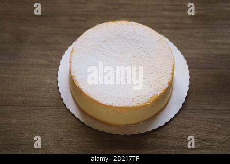 whole cheesecake or german cheese cream tart or torte on rustic wooden table