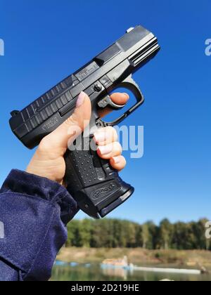 Police gun in a woman's hand Stock Photo