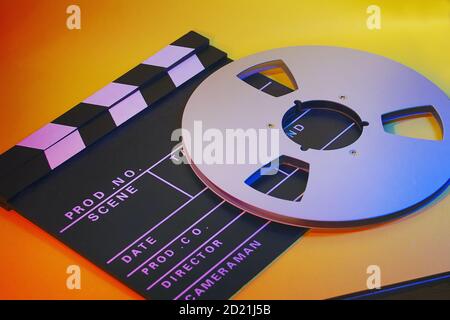 Close up of a film board and a tape spool in a vibrant background. A cinema, movie concept Stock Photo