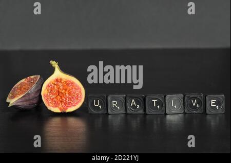 Idea Figurative made from Figs and Scrabble Tile Word on black table Stock Photo