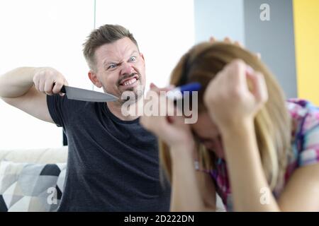 Angry husband threatens to stab his wife with pregnancy test in apartment Stock Photo