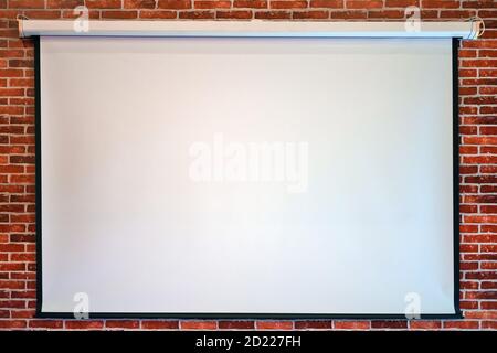 White canvas on a brick wall for showing movies on a projector, copy space for text Stock Photo