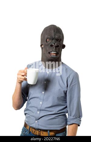 Man wearing gorilla mask holding coffee mug on isolated white background. Medium shot. Stock Photo