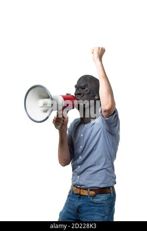 Man in gorilla mask protesting on megaphone. Isolated cutout on white background. Medium shot. Side view. Stock Photo