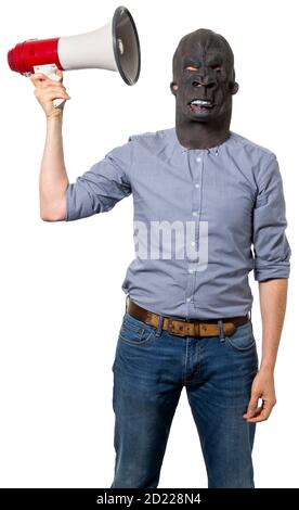 Man wearing gorilla mask holding up megaphone next to head. Isolated cutout on white background. Three quarter length. Stock Photo