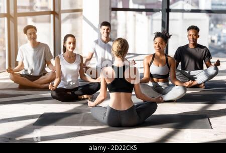 Group Of Young Multhiethnic People Practicing Yoga With Instructor During Group Lesson Stock Photo