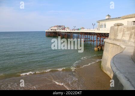 Landscape seaside Cromer Pier beach and promenade Norfolk East Anglia across the sandy shore calm sea water on holiday Summer Stock Photo