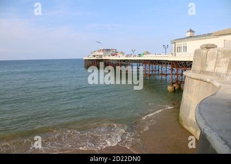 Landscape seaside Cromer Pier beach and promenade Norfolk East Anglia across the sandy shore calm sea water on holiday Summer Stock Photo