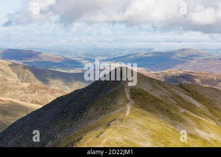 Helvellyn, Cumbria, UK - 29/09/20: On the summit of Catstycam, at the end of a path, three walkers pause to look at the Lake District scenery. Stock Photo