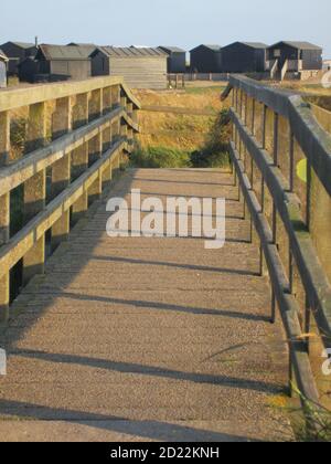 Summer Landscape scene at Walberswick near Southwold in Suffolk East Anglia from the wooden bridge to campsite stony beach & huts on sand dunes Stock Photo