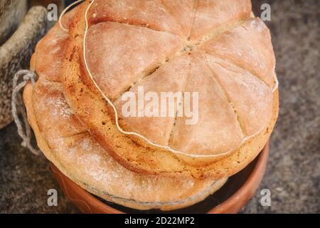 The bread baked at the retro technology of ancient Rome. Reconstruction of cooking in the ancient era. Roman bread, reconstruction. Stock Photo