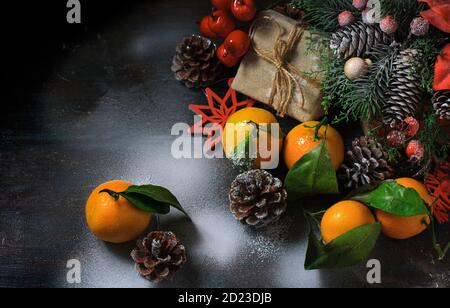 Christmas New Year composition with tangerines. Gift Box, cones on a dark wooden background. Stock Photo