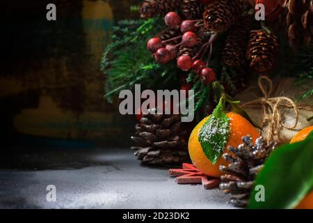 Christmas New Year composition with tangerines. Gift Box, cones on a dark wooden background. Stock Photo