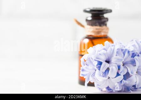 Bottle with essential oil and with lilac flowers on a white background. Macro. Stock Photo