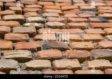 Red brick wall in receding perspective. Geometric composition of rectangular clay bricks. Multitasking background. Without anyone. Stock Photo