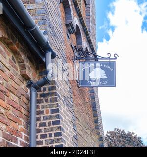 Pinner Hill Farm The Folly Extended sign with illustration of a tree on the side of Grade II listed Tooke’s Folly Clock Tower. Harrow, NW London Stock Photo