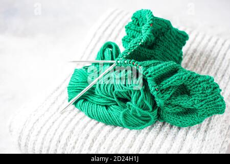 Green knitting yarn and knitting needles close-up. Stock Photo