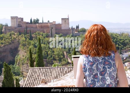 Woman enjoying the view of the Alhambra the ancient arabic fortress located in Granada, Spain Stock Photo