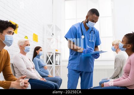 Doctor Working With Diverse Patients In Hospital During Coronavirus Vaccination Stock Photo