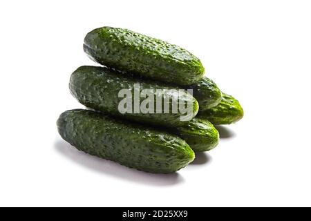 Heap of fresh green prickly cucumbers isolated on white background Stock Photo