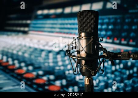 Condenser microphone with mixing desk in the background Stock Photo