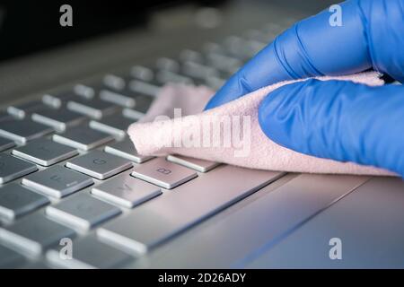 disinfecting measures to protect against coronavirus or other microbes. prevention of viral infection. hand in a blue glove with a pink rag close up Stock Photo