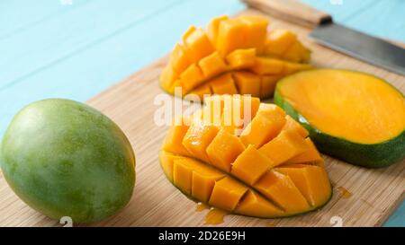 Delicious ripe mango cut in chunks on a wooden cutting board. Tropical fruit juicy mango Stock Photo