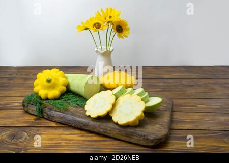 Green zucchini and yellow pattison, chopped on a dark wooden board. Mono diet concept, healthy food. Selective focus, dark wooden background. Stock Photo