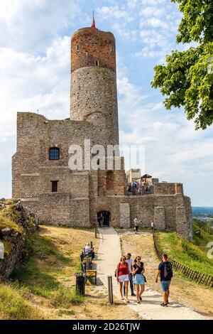Checiny, Swietokrzyskie / Poland - 2020/08/16: Tourists in front of Prison Tower and Eastern Gate of Checiny Royal Castle medieval fortress in Swietok Stock Photo