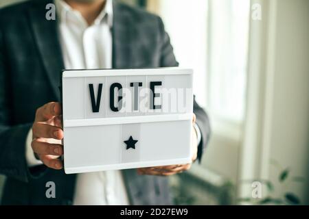 The word VOTE written on lightbox in men's hands. Election concept. Stock Photo