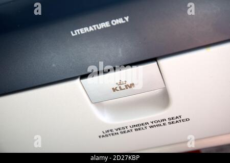 'Literature only – KLM – Life vest under your seat – Fasten seat belt while seated', text on backside of seat in KLM plane Stock Photo