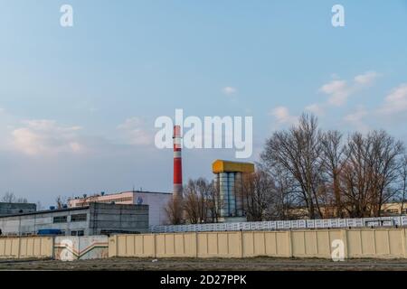 Red and white old brick industrial pipe on blue sky background. The old image of the Industry concept. Ecology, industrial renewal, globalization. Stock Photo
