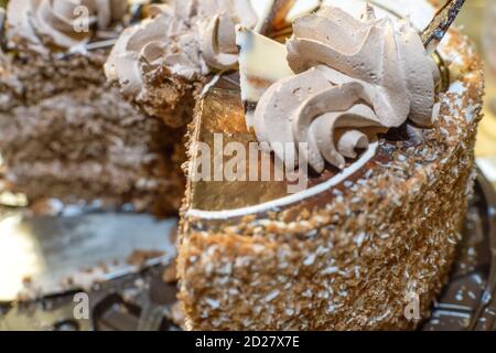 Chocolate cream cake cut into pieces close up Stock Photo