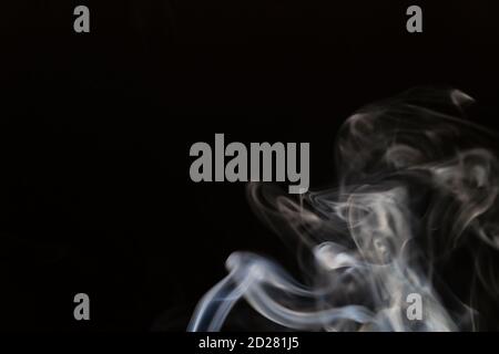 Abstract smoke background with copy space on black background. Blue-white smoke rising from the incense stick Stock Photo